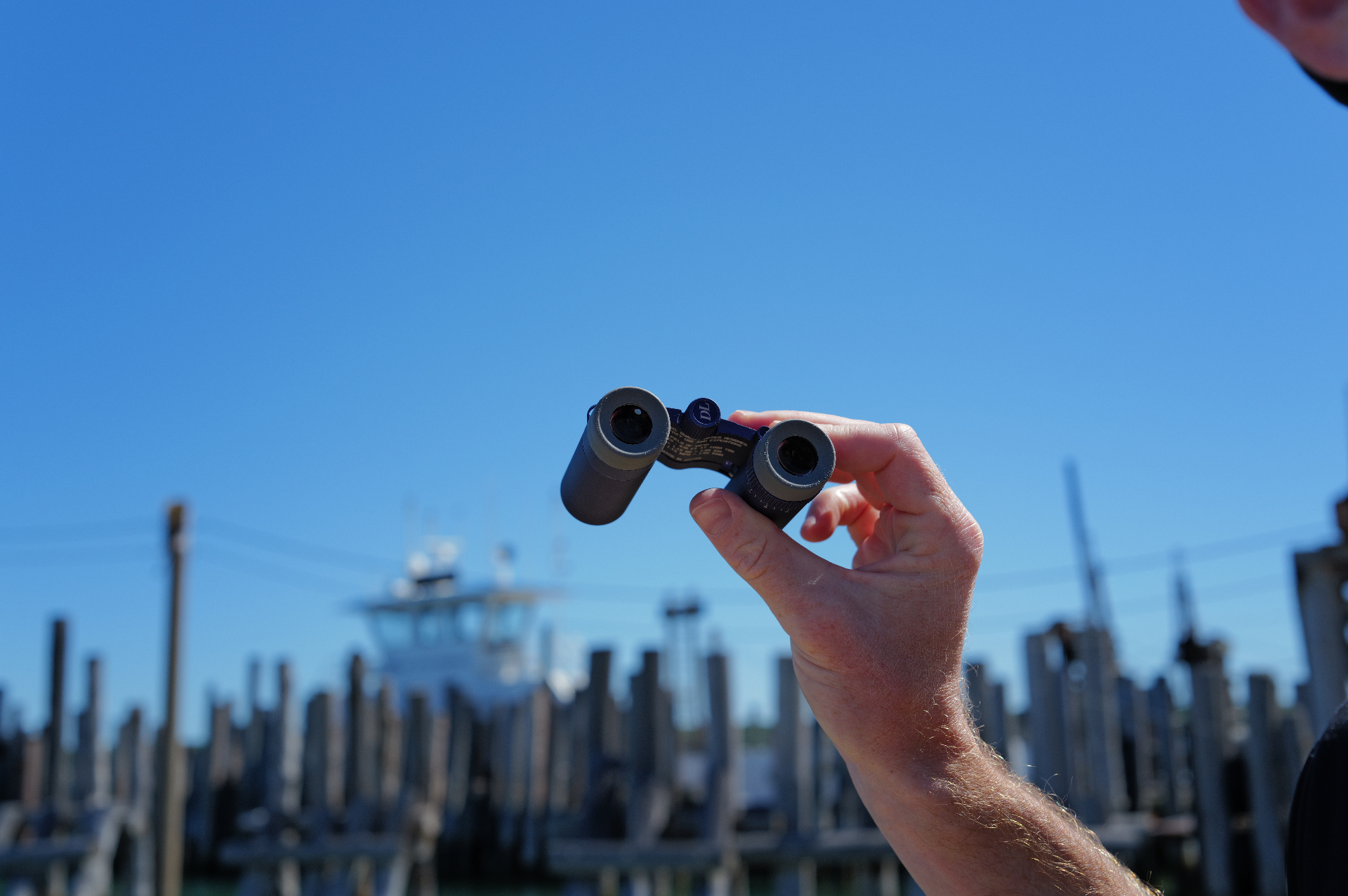 Double Lion binoculars held against a harbor backdrop