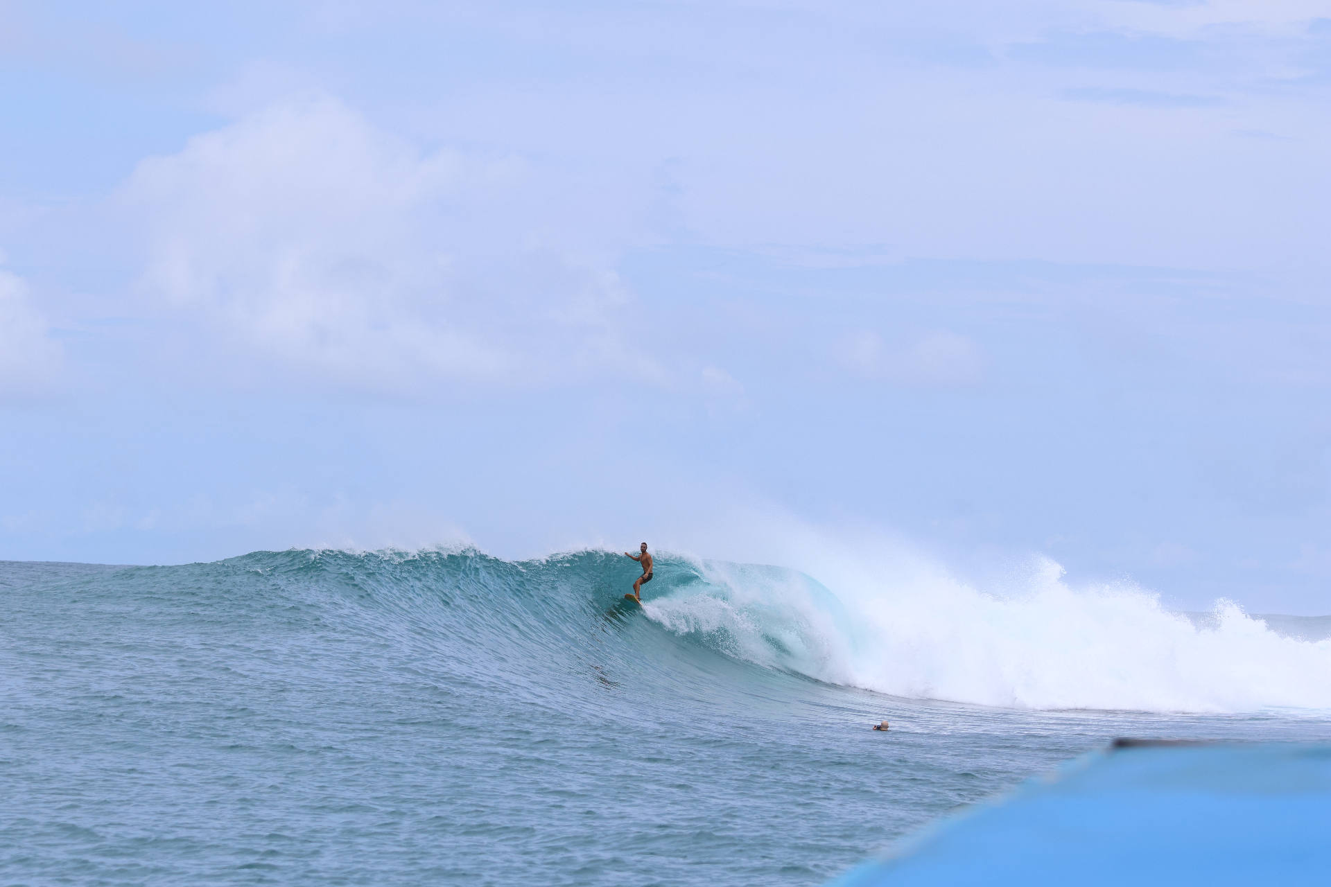 Surfer riding a wave in remote tropical waters